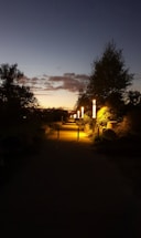 A cozy outdoor pathway softly lit by warm solar lights at dusk.