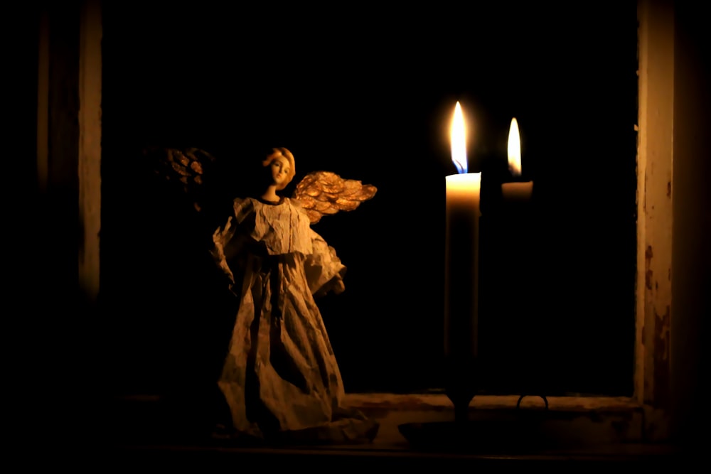 man in white robe holding candle