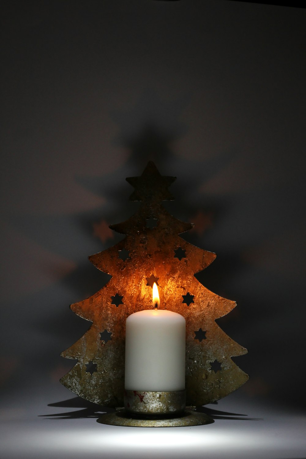 white pillar candle on brown tree