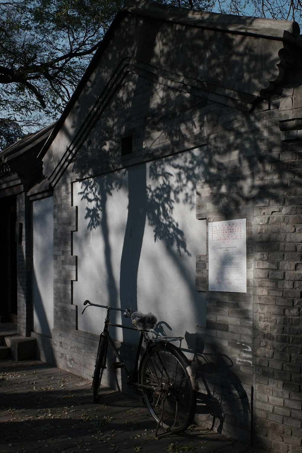 black commuter bike parked beside brown concrete wall