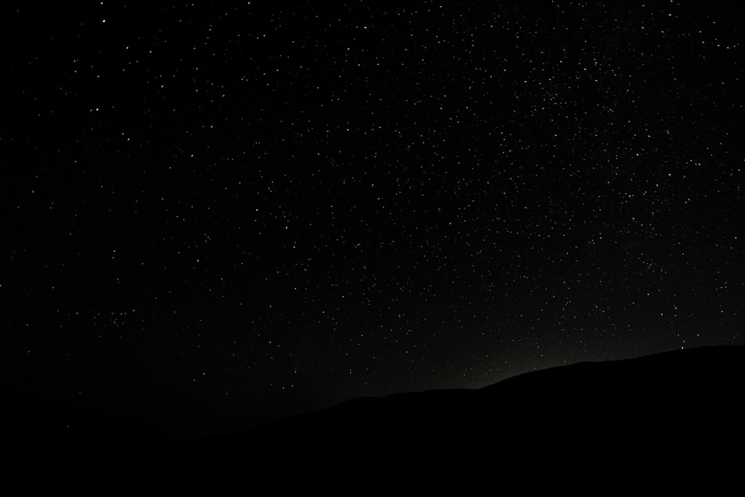 silhouette of mountain under starry night