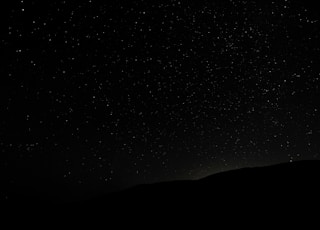 silhouette of mountain under starry night