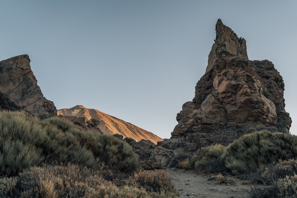 brown rock formation near green grass during daytime