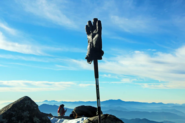 Close-up of durable hiking gloves resting on rocky terrain with mountain backdrop