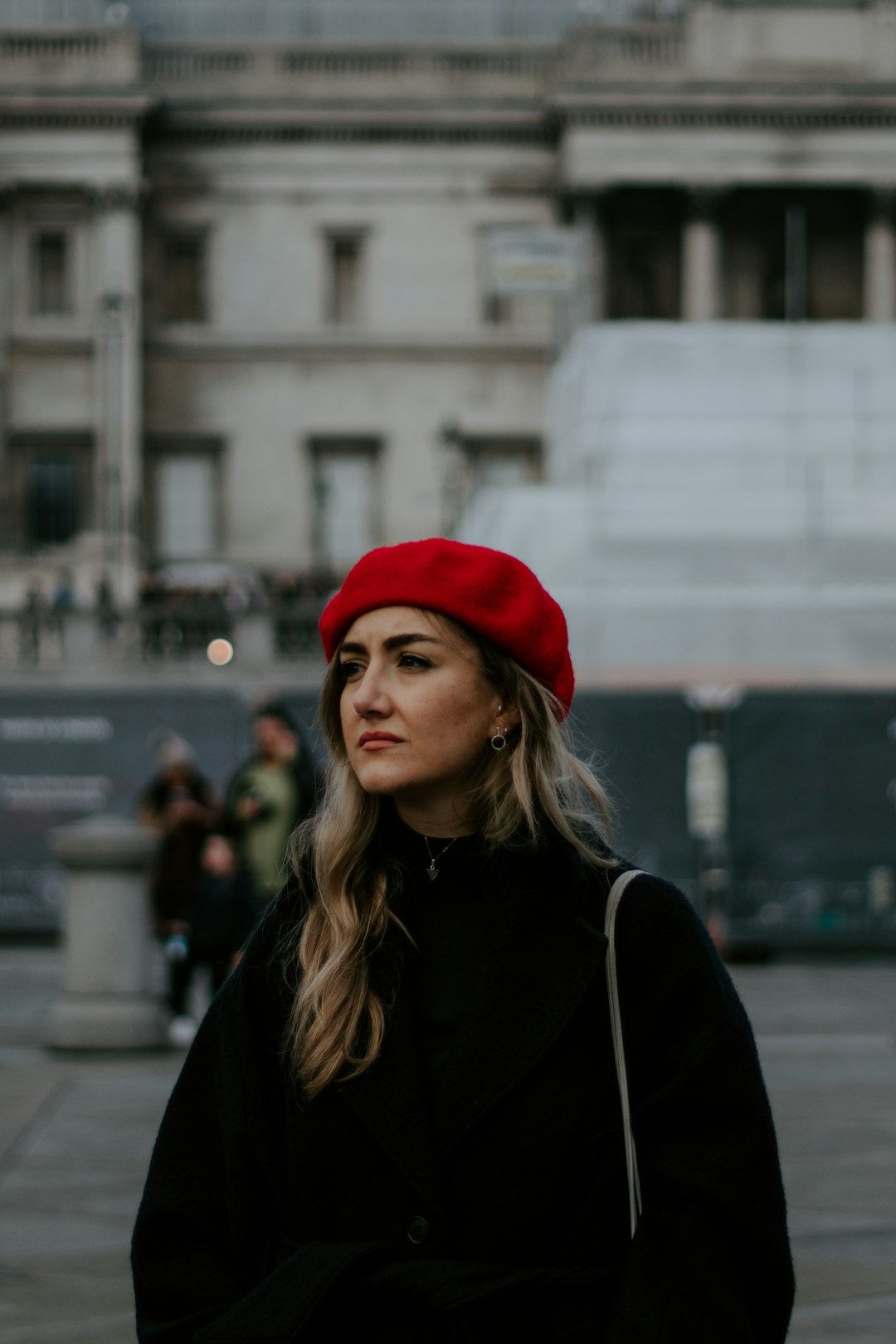 woman in black jacket and red knit cap