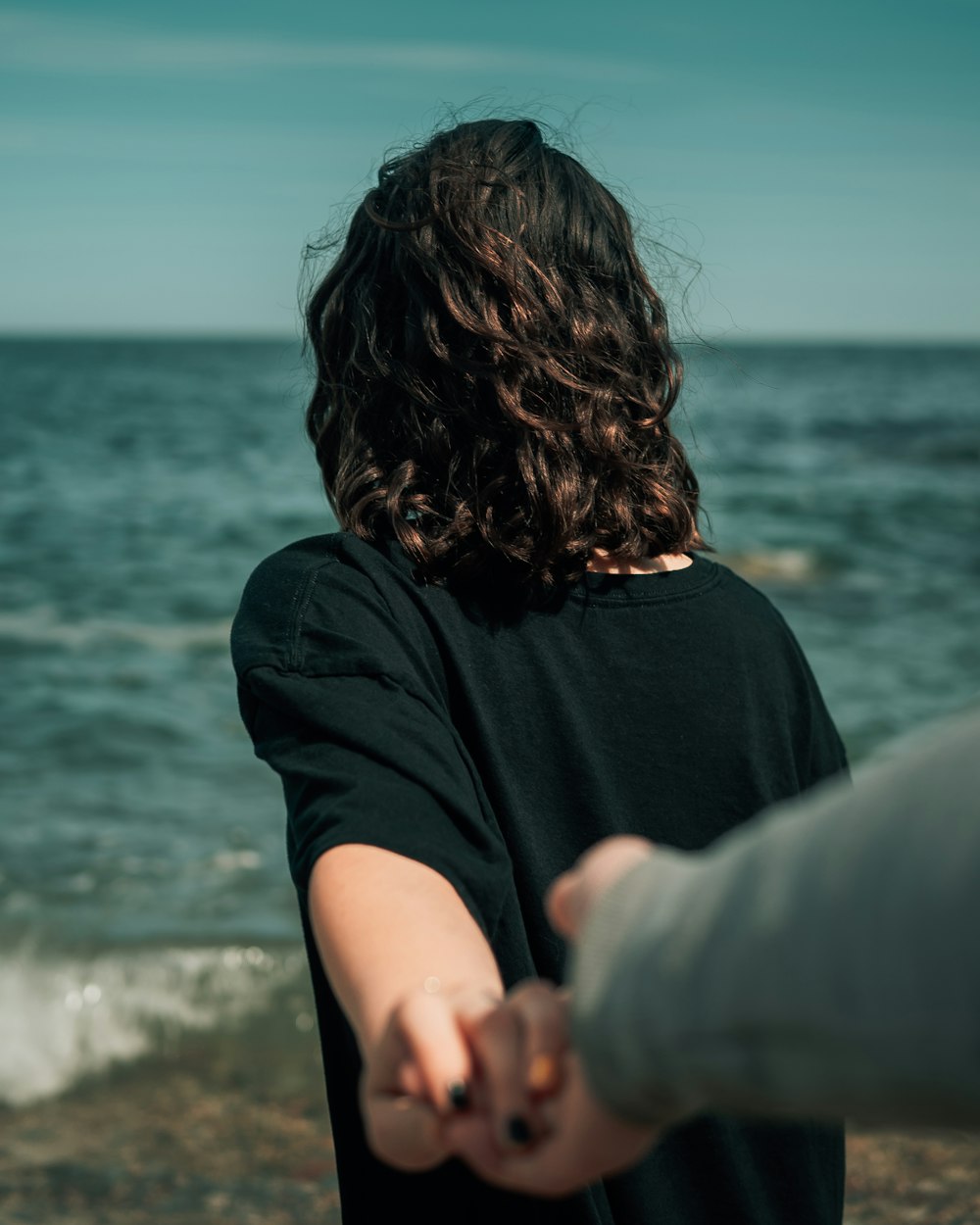 woman in black shirt standing near body of water during daytime