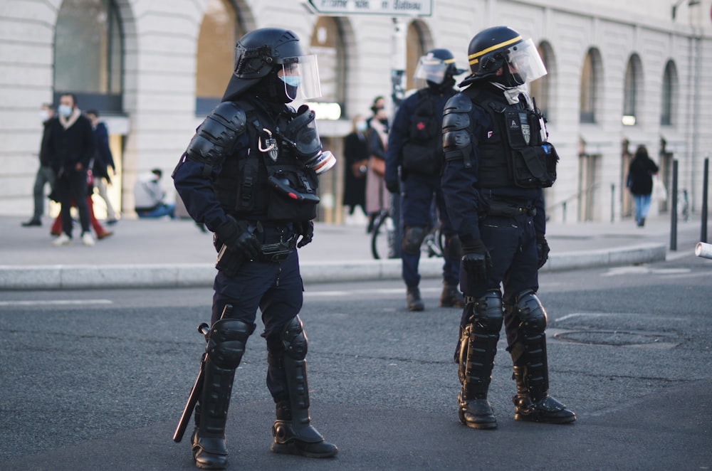 白黒のヘルメットをかぶった2人の男性と、昼間に通りを歩く黒いヘルメット