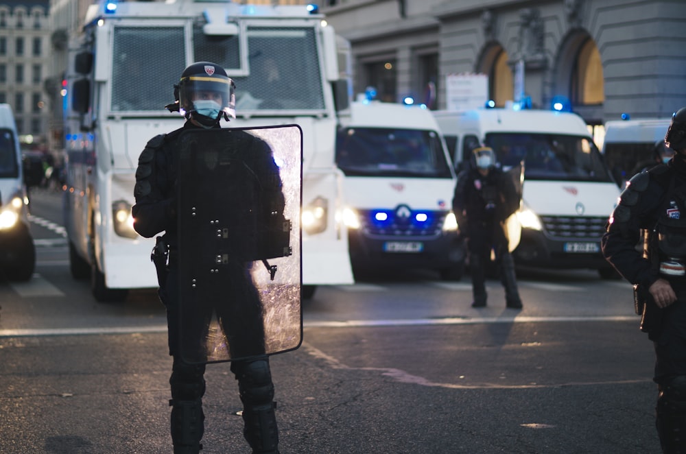 homme en veste noire debout sur la voie piétonne pendant la journée