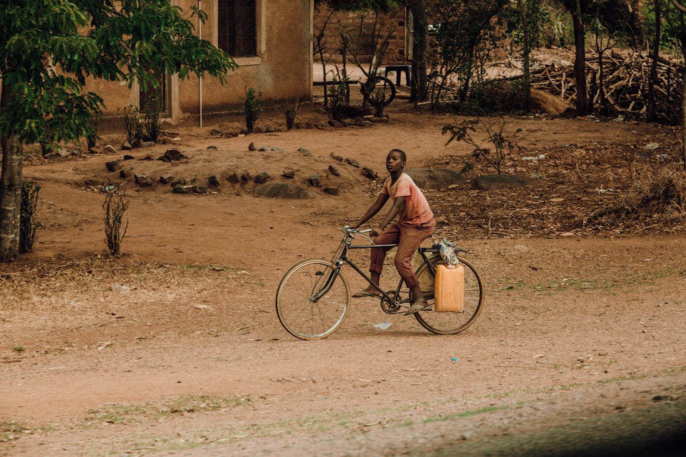 man in brown shirt riding on black city bike during daytime