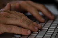 Close-up of hands typing on a keyboard with SEO analytics on screen.