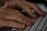 Close-up view of hands typing on a computer keyboard. The fingers are poised over the keys, suggesting active engagement with typing or data entry.