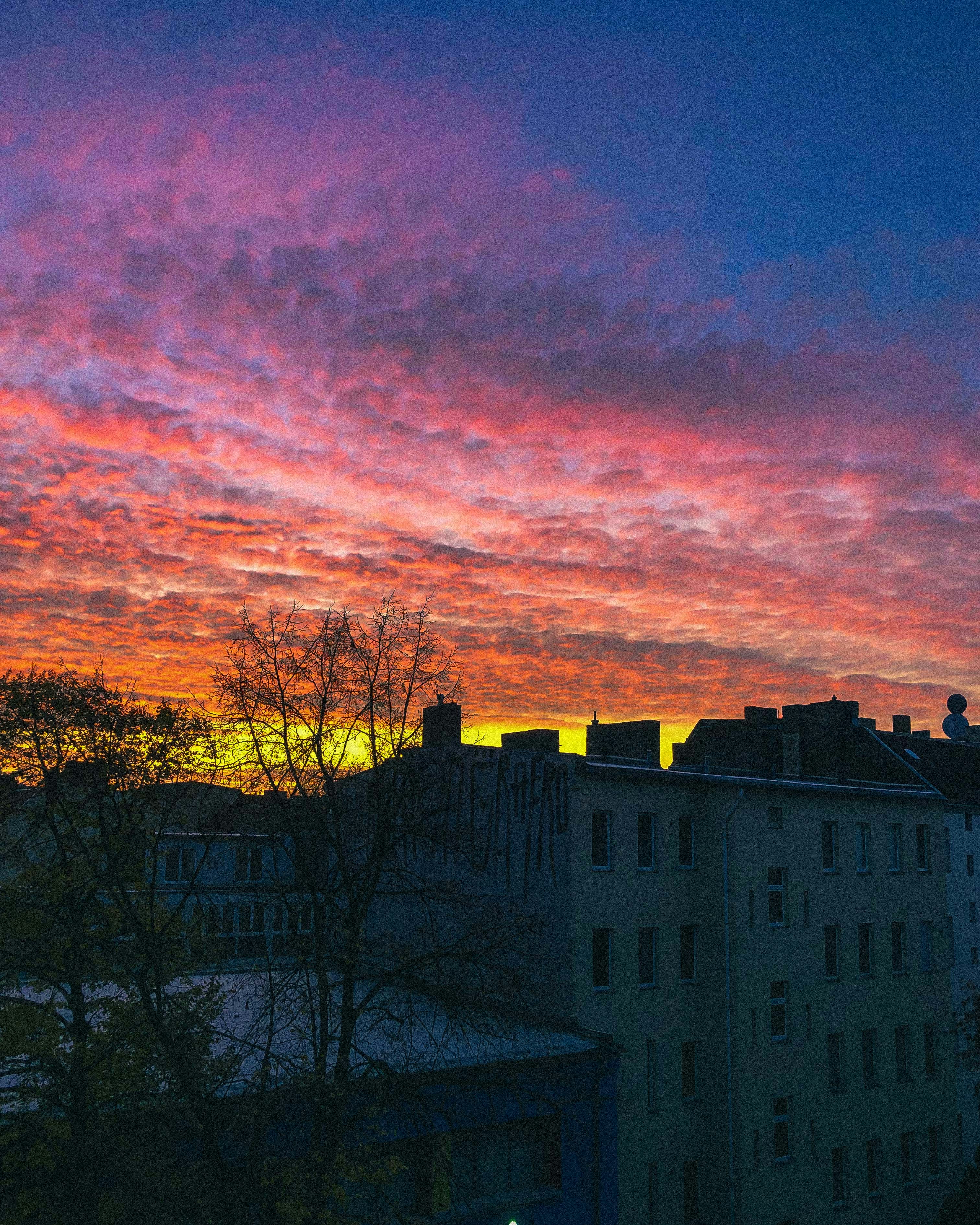 brown and black concrete building under orange and blue sky