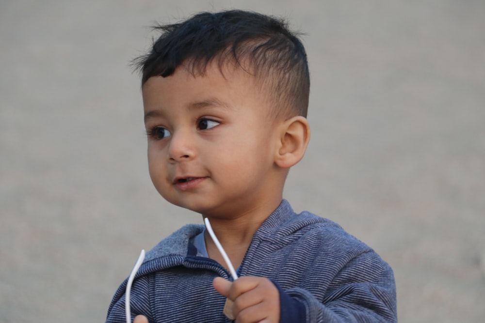 Niño con sudadera con capucha azul y blanca