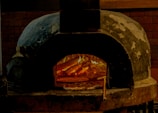 A warm, rustic pizza oven glowing with fire inside Al Circolino pizzeria.