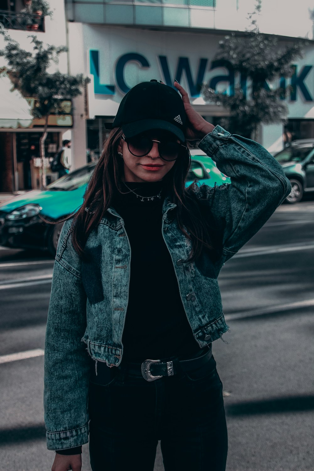 woman in blue denim jacket standing on road during daytime