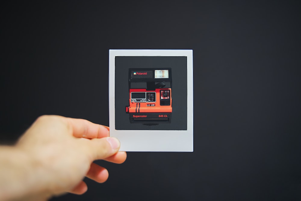 person holding white picture frame