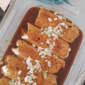 Chefs preparing traditional enchiladas mineras in a rustic kitchen.