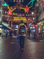 A vibrant cityscape with a traveler wearing a bright iim explorers backpack walking through colorful streets.