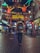 A young traveler exploring a vibrant city street with a backpack and a camera.