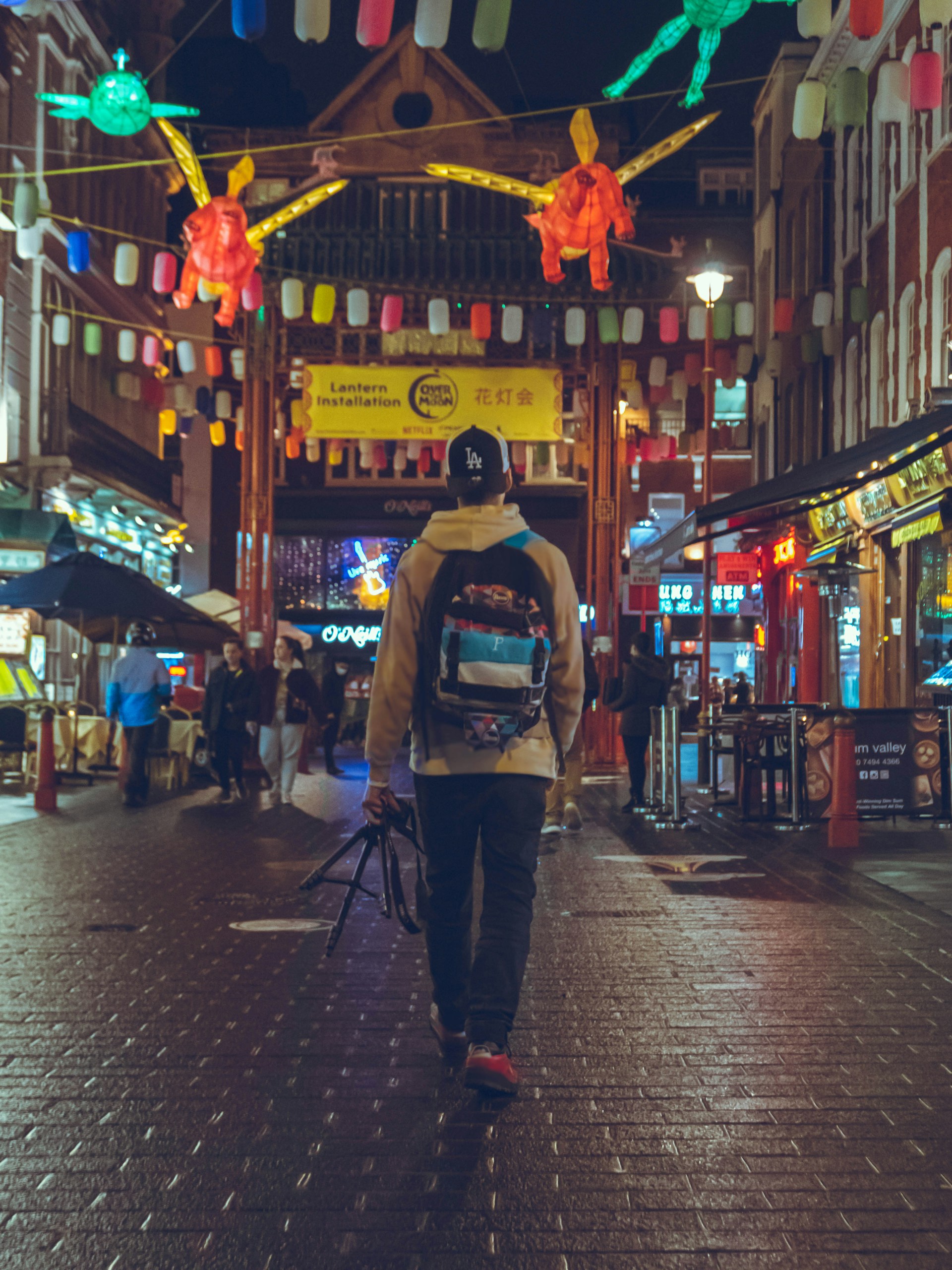 A solo traveler exploring a vibrant international city street filled with lively markets and historic architecture.