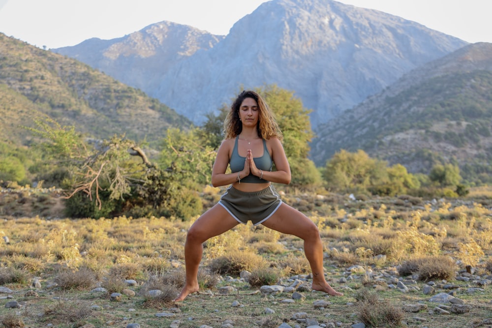 woman in black bikini sitting on rocky ground during daytime