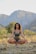 A serene outdoor scene with a person meditating in nature.