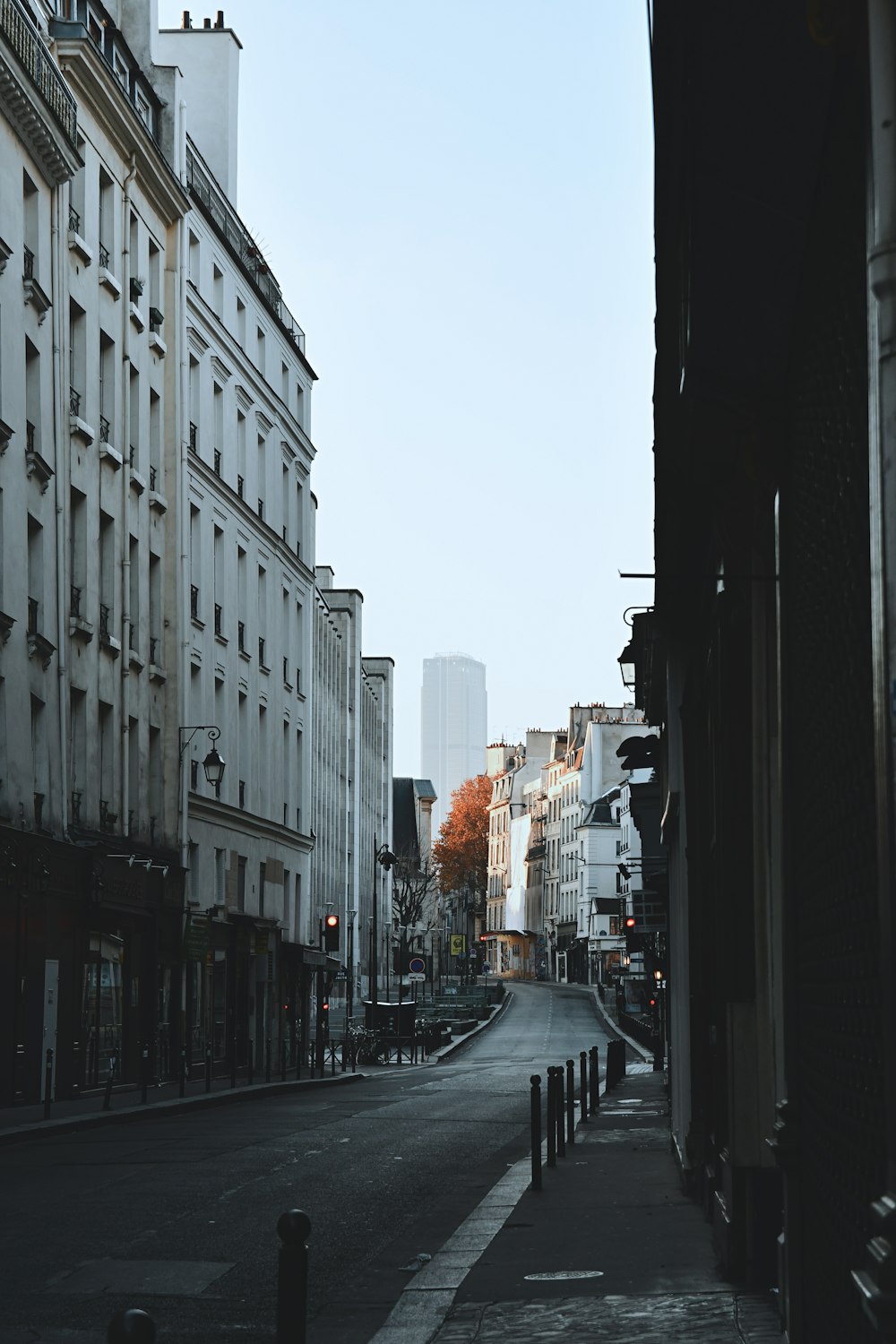 cars parked on side of the road in between high rise buildings during daytime