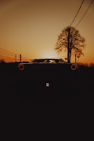 A dramatic sunset shot of a race car parked beside the track, highlighting the team’s dedication and spirit.