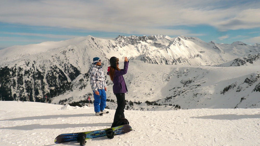 homme et femme debout sur le sol enneigé pendant la journée