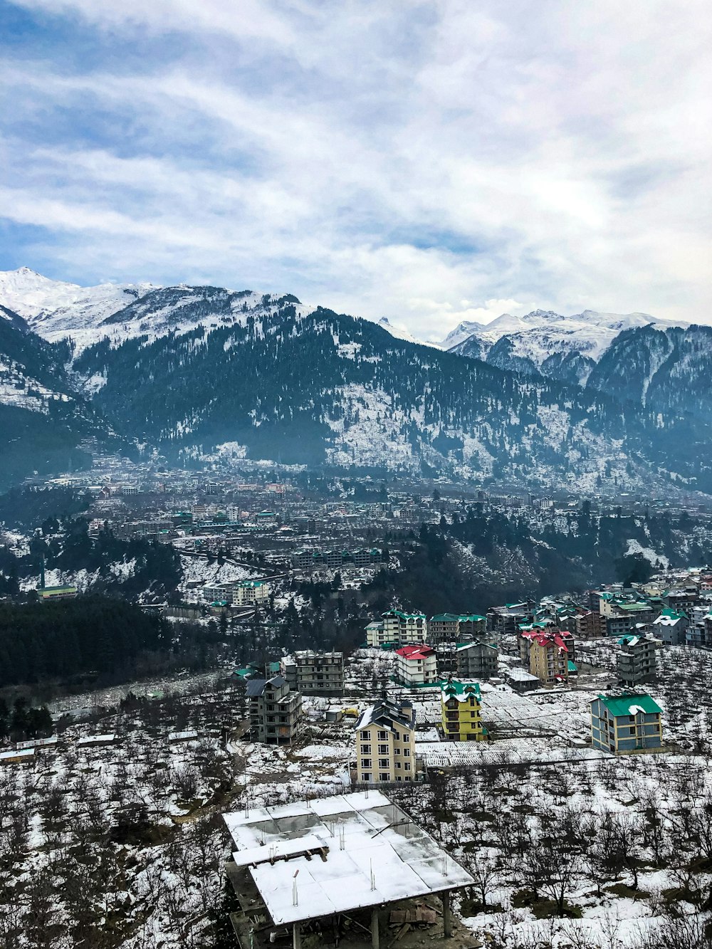 日中の雪に覆われた山々の近くの街の空撮