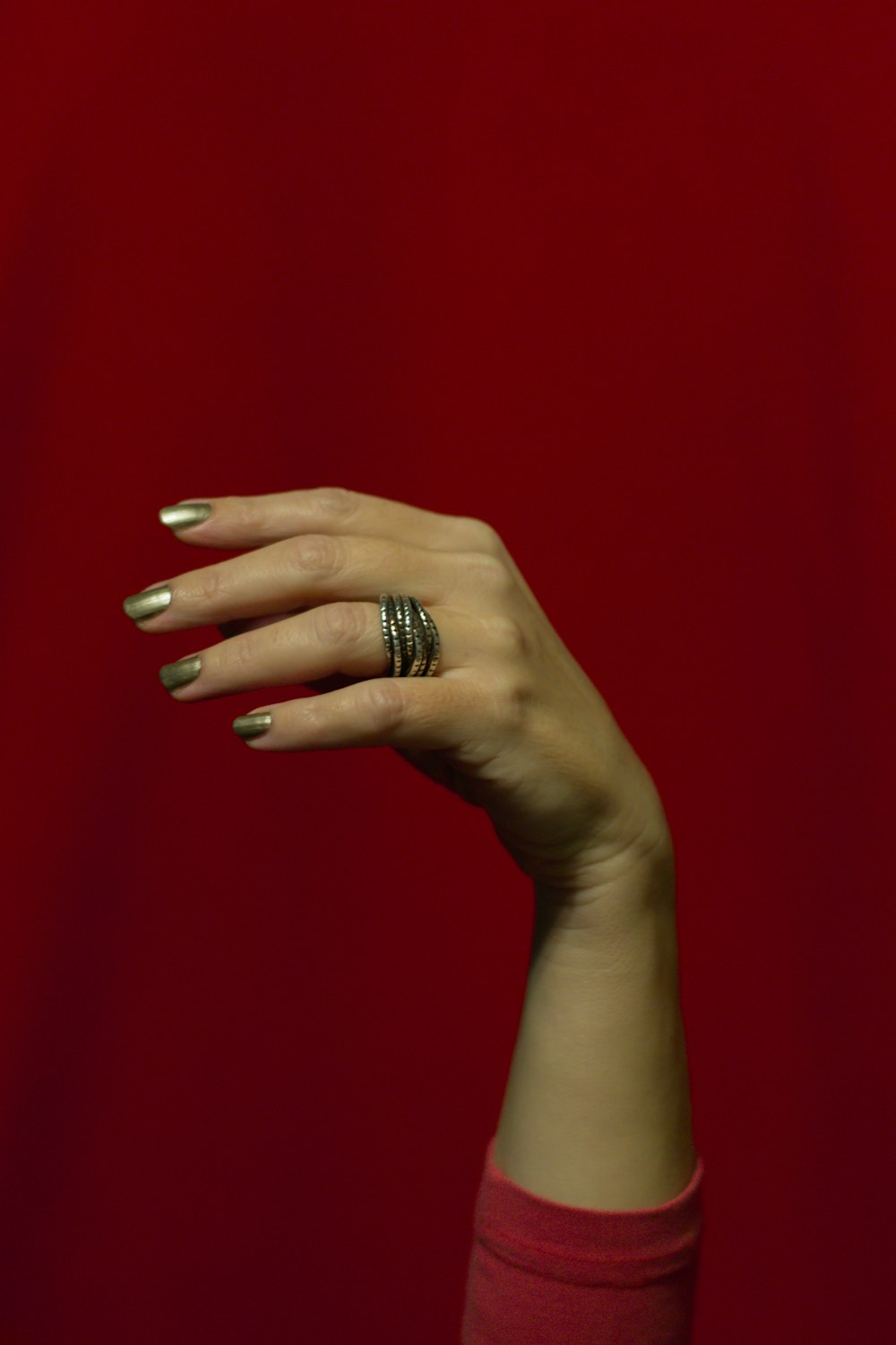 person wearing silver ring on red textile
