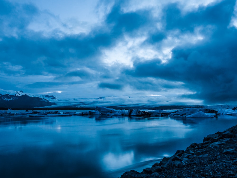 specchio d'acqua sotto il cielo nuvoloso durante il giorno