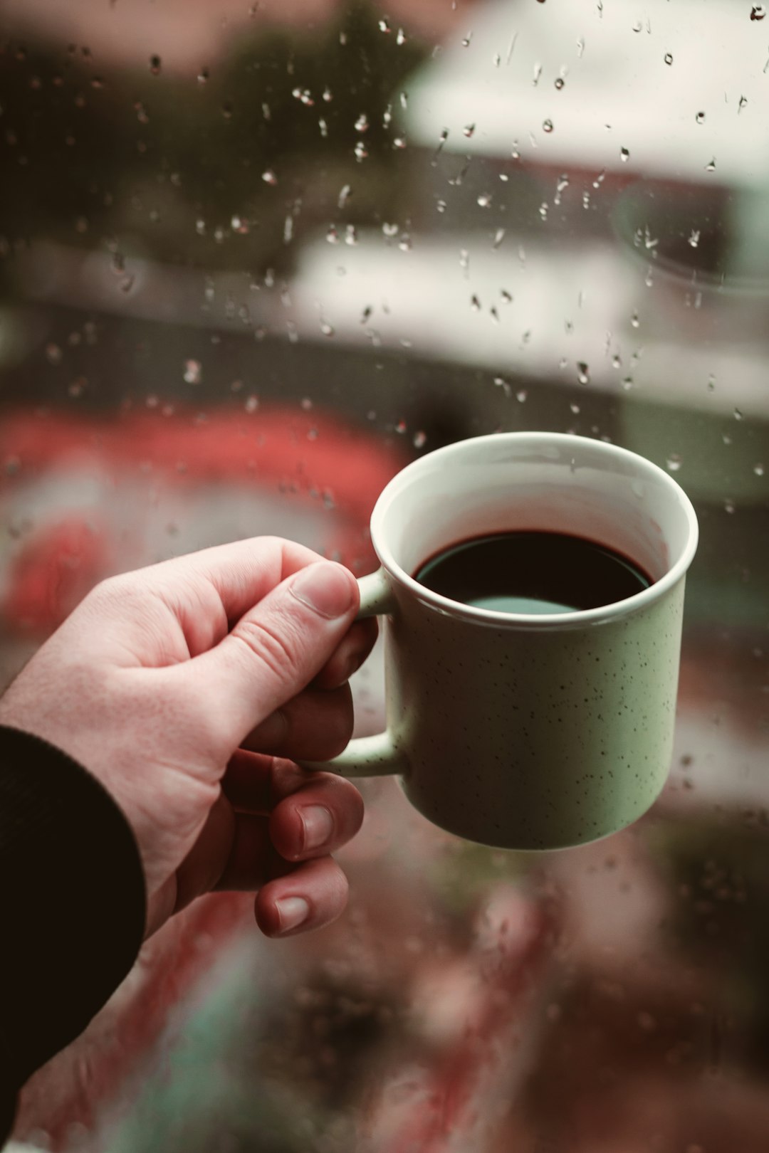 person holding green ceramic mug with coffee