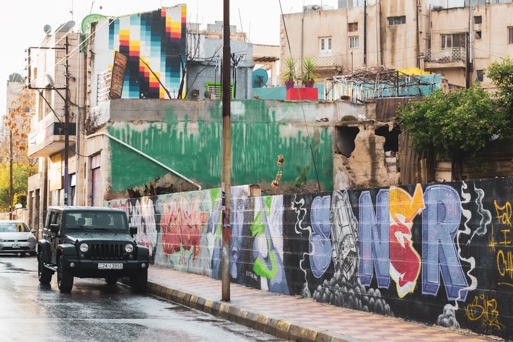 black car parked beside green and white wall