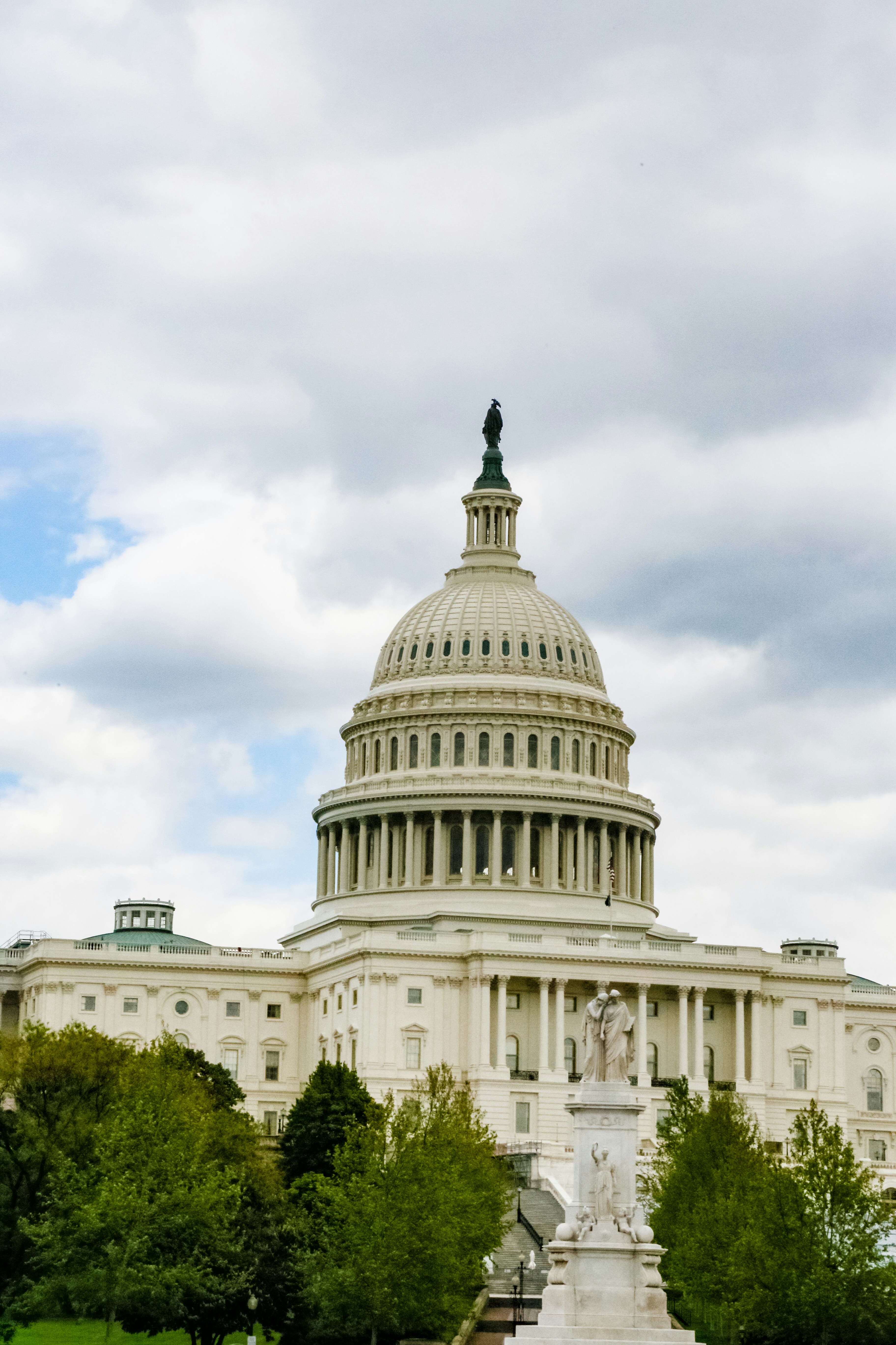 white concrete building under white clouds during daytime