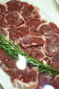 Selection of plump, pink pork chops arranged neatly with sprigs of rosemary.