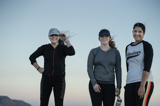 Smiling diverse women wearing stylish gym apparel and jewelry outdoors