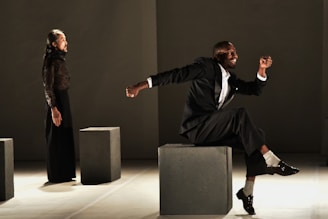 man in black suit sitting on gray chair
