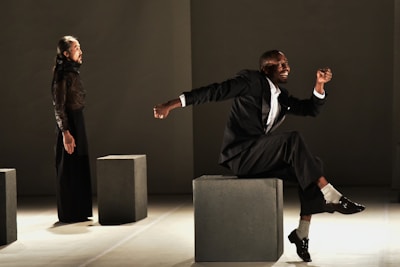 man in black suit sitting on gray chair