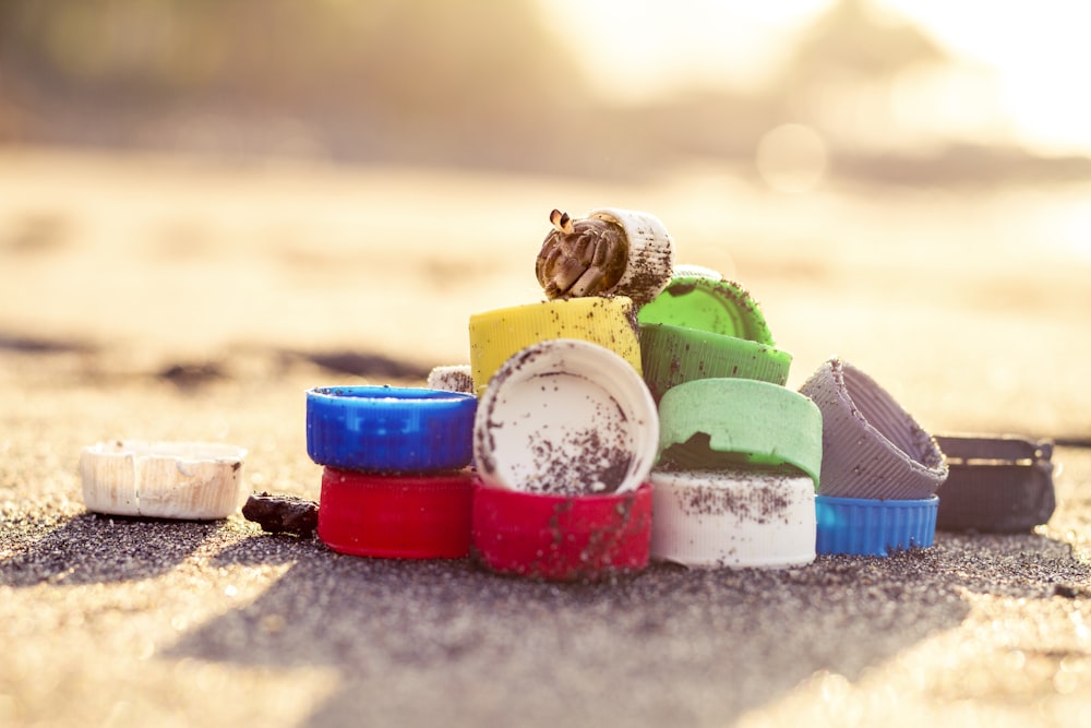 Récipients en plastique bleu et rouge sur sable gris