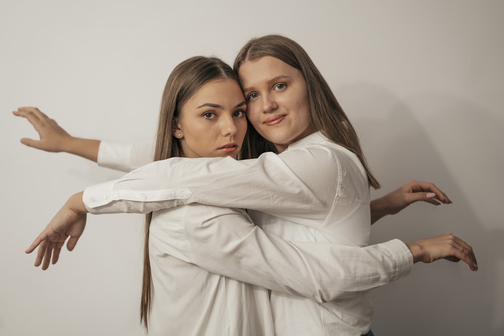 woman in white long sleeve shirt hugging woman in white long sleeve shirt