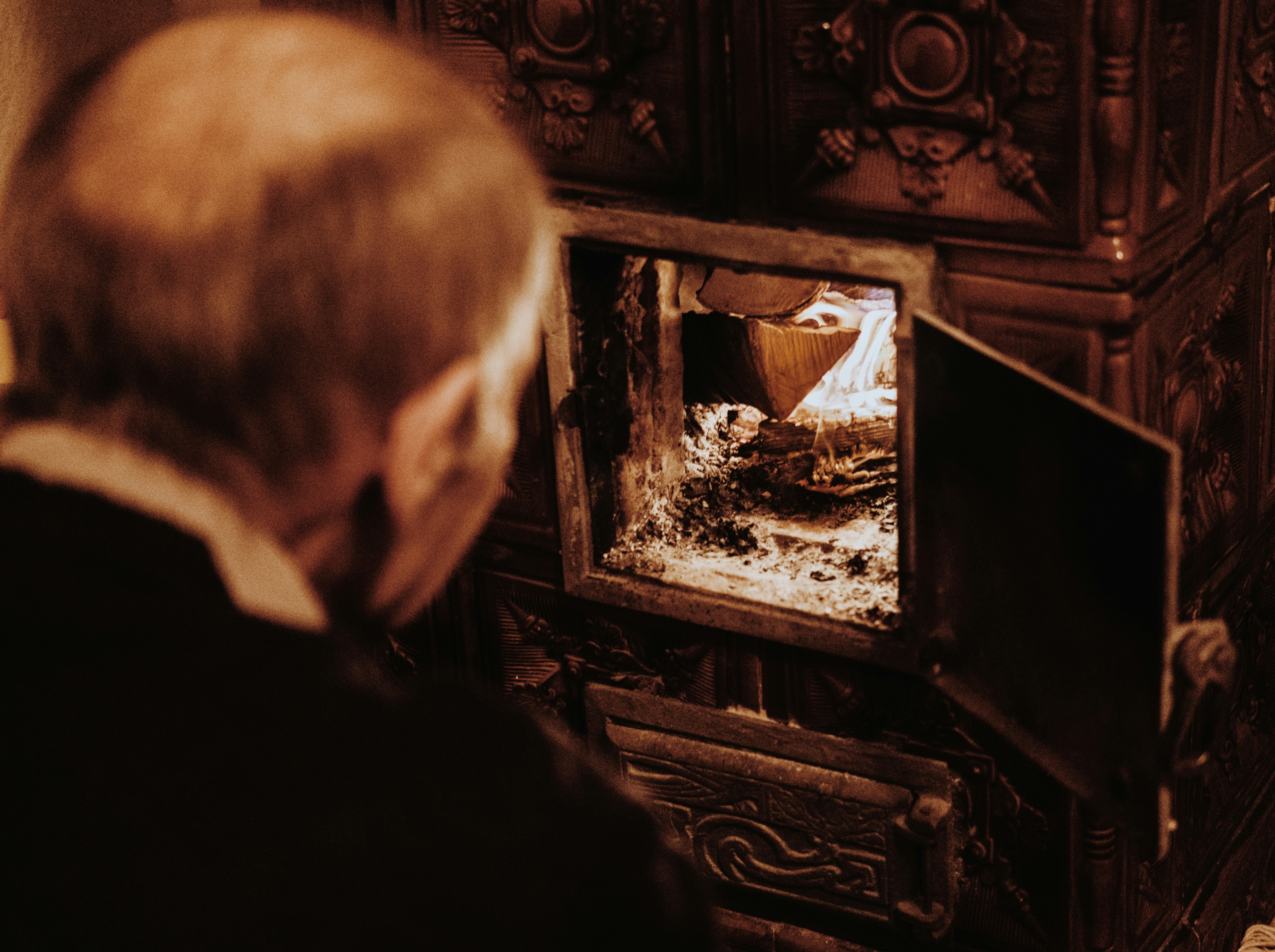 man in black jacket looking at fire