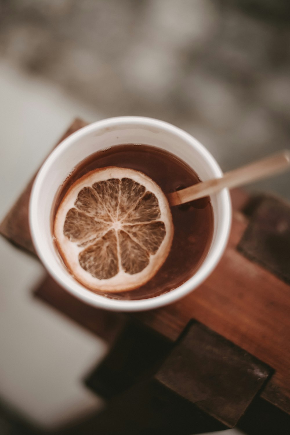 Liquide brun dans une tasse en céramique blanche avec des tranches de citron