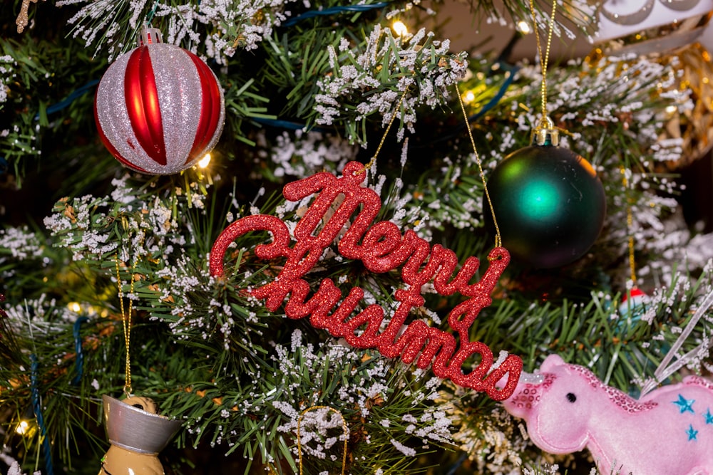 a christmas tree decorated with ornaments and a happy christmas sign