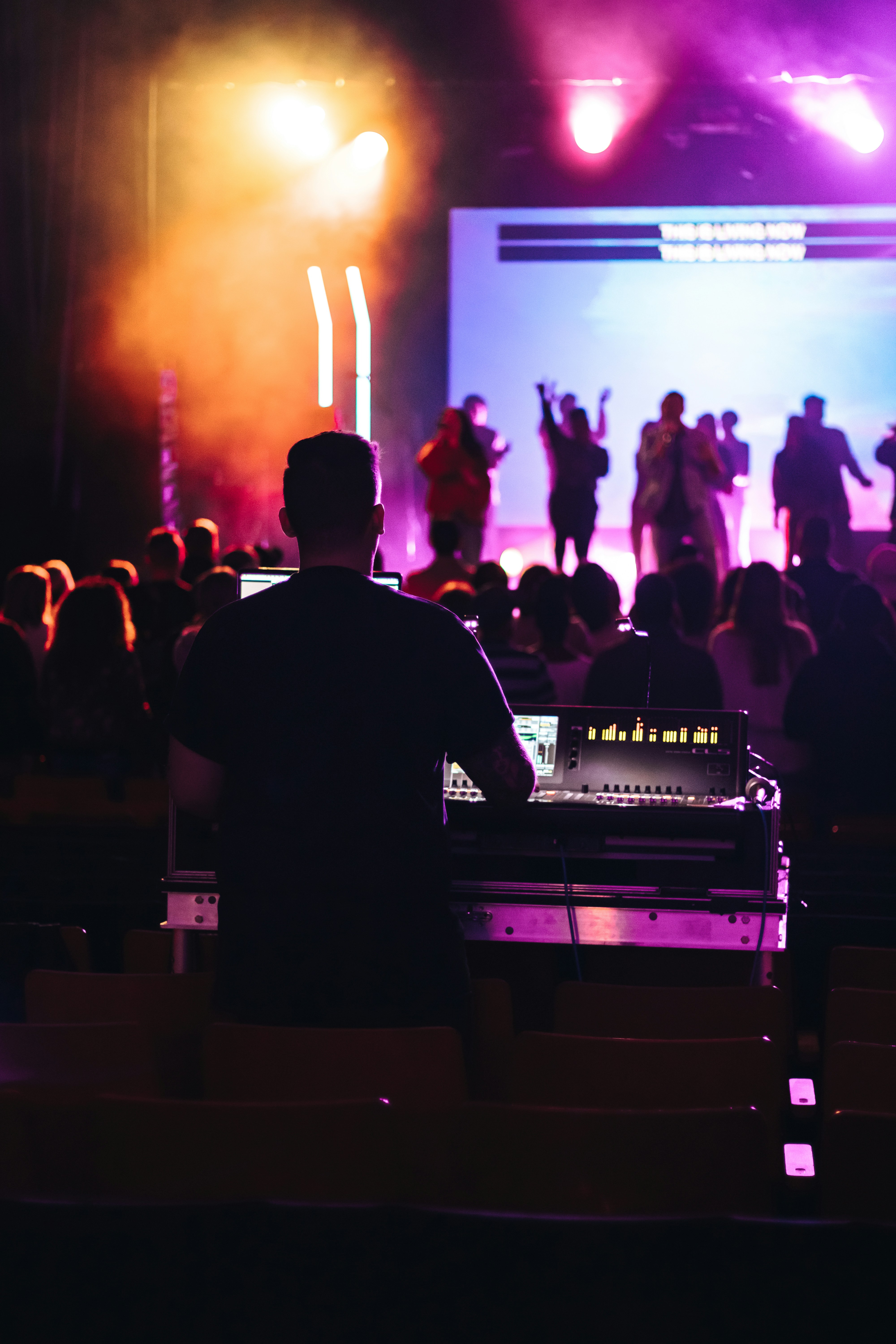 man in black crew neck t-shirt standing on stage