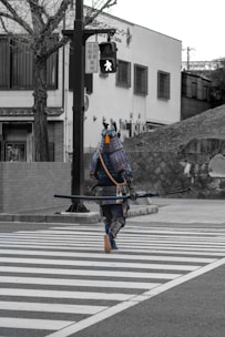 man in blue and black suit holding black rifle walking on pedestrian lane during daytime