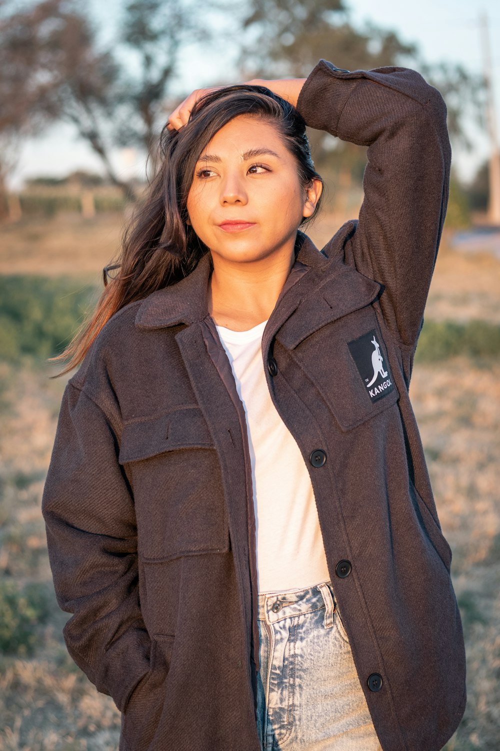 woman in brown coat standing during daytime