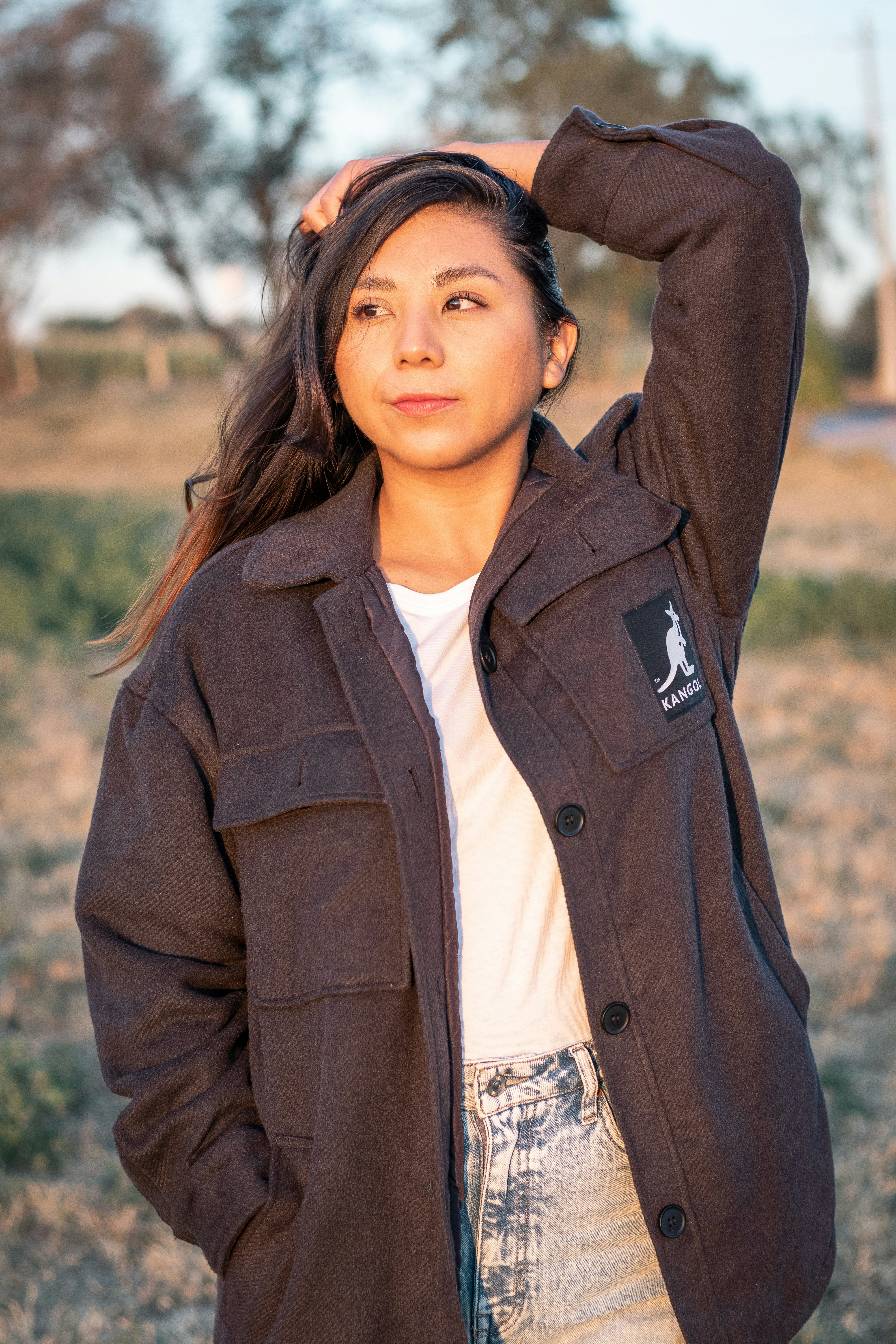 woman in brown coat standing during daytime