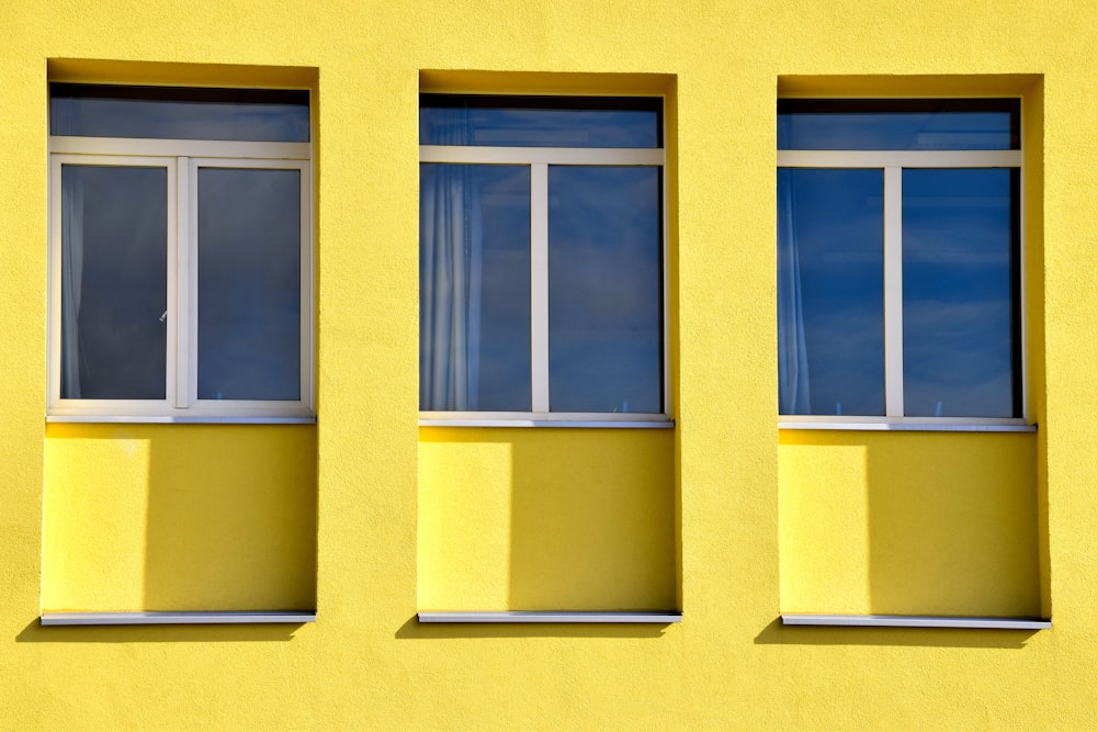edificio in calcestruzzo giallo con finestre di vetro