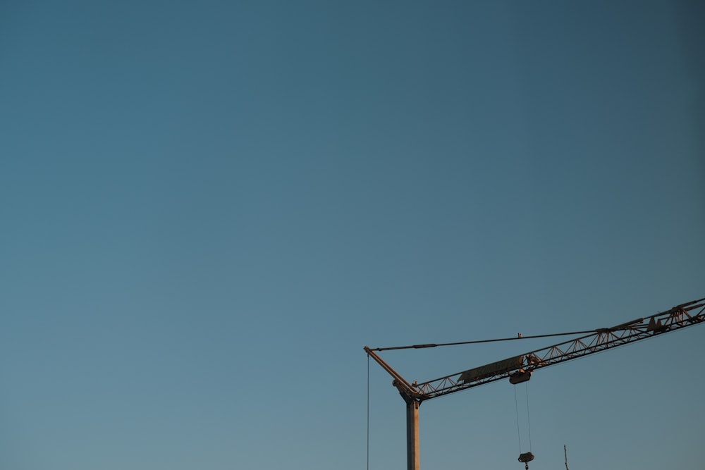 yellow metal crane under blue sky during daytime